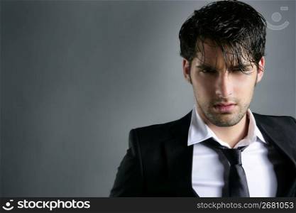 Fashion trendy suit young handsome man messy hairstyle dark portrait on gray