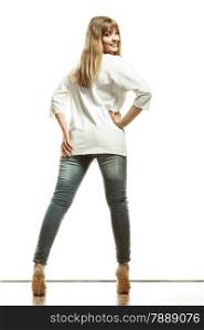 Fashion. Woman full length in denim trousers high heels shoes casual style white top back view isolated