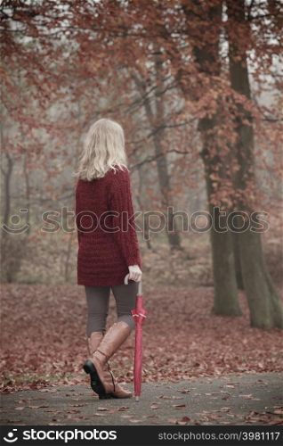 Fashion woman girl in maroon sweater with umbrella walking relaxing in fall autumn park. Relax in forest.. Fashion woman with umbrella relaxing in fall park.