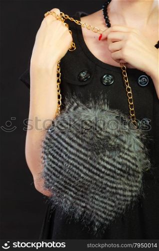 Fashion. Woman hand holding evening small round gray handbag on black background