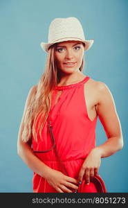 Fashion woman in hat and red shirt with handbag.. Cute woman girl in red shirt and straw hat with handbag in studio on blue. Summer female fashion vogue.