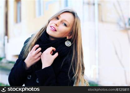 Fashion woman outdoor portrait. Beautiful girl posing on the street in black coat. Photo toned style instagram filters