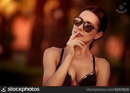 Fashion woman portrait, beautiful woman wearing stylish sunglasses and swimsuit, gorgeous female model outdoors, summer vacation look