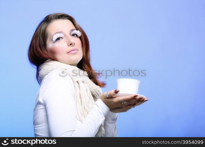 Fashion woman stylish winter makeup holding cup of hot drink beverge enjoying coffee time copyspace blue background