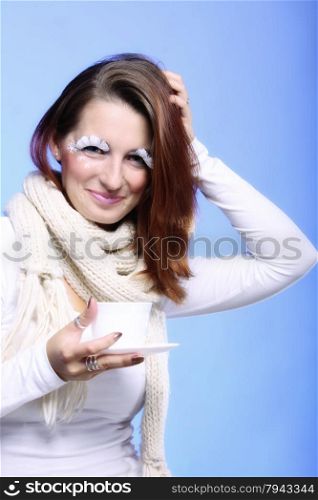 Fashion woman stylish winter makeup holding cup of hot drink beverge enjoying coffee time copyspace blue background
