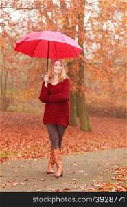 Fashion woman with umbrella relaxing in fall park.. Smiling happy fashion cute woman girl in maroon sweater with umbrella relaxing in fall autumn park. Happiness and relax in forest.