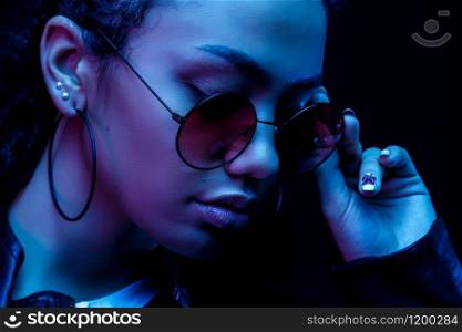 Fashion young African girl black woman hold stylish pink glasses looking at the camera isolated on a black Studio background, horizontal banner for website design, portrait, copy space