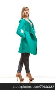 Fashion. Young blonde fashionable woman in full body wearing vivid color green blue wool coat high heels shoes. Female model posing isolated on white
