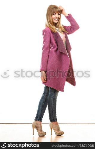 Fashion. Young blonde fashionable woman in vivid color pink coat. Female model posing isolated on white background
