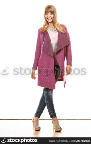 Fashion. Young blonde fashionable woman in vivid color pink coat. Female model posing isolated on white background