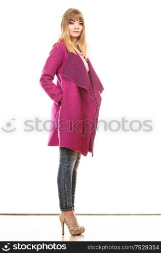 Fashion. Young blonde fashionable woman in vivid color pink coat. Female model posing isolated on white background