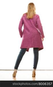 Fashion. Young blonde fashionable woman in vivid color pink coat. Female model rear view isolated on white background