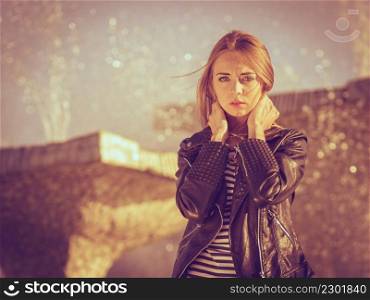 Fashion young blonde woman casual style posing against city fountain