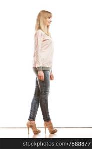 Fashion. Young blonde woman denim pants bright shirt high heels. Female model posing in full length isolated