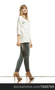 Fashion. Young blonde woman denim pants white bat sleeve top high heels. Female model posing in full length isolated