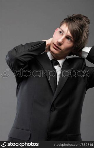 Fashion young businessman black suit casual tie on gray background