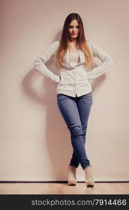 Fashion. Young long hair fashionable woman jeans pants shirt. Female model posing in full body filtered photo