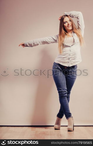 Fashion. Young long hair fashionable woman jeans pants shirt. Female model posing in full body filtered photo