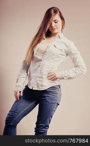 Fashion. Young long hair fashionable woman jeans pants shirt. Female model posing filtered photo