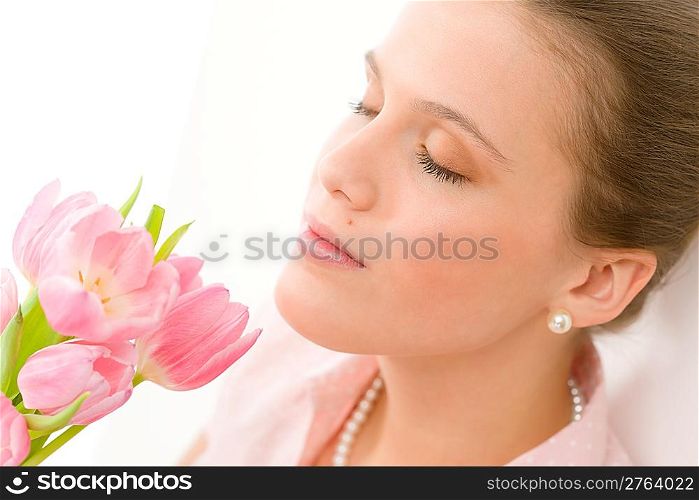 Fashion - young romantic woman smell spring tulips in designer clothes