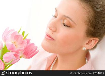 Fashion - young romantic woman smell spring tulips in designer clothes