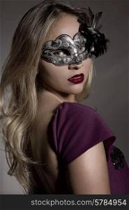fashion young woman with a mask on a grey background