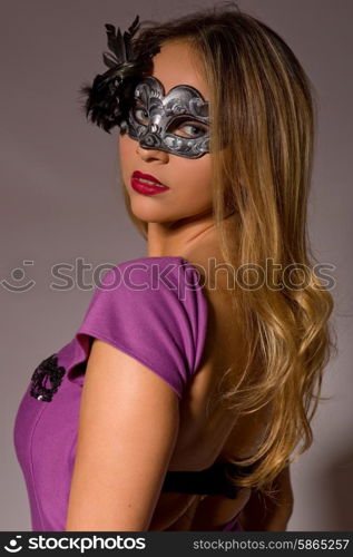 fashion young woman with a mask on a grey background