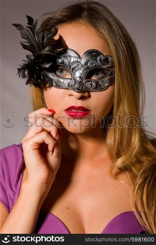 fashion young woman with a mask on a grey background