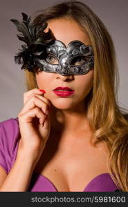 fashion young woman with a mask on a grey background