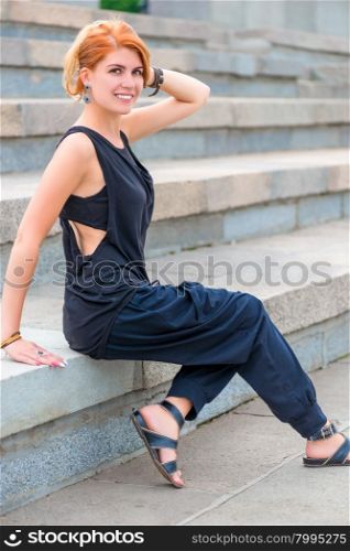fashionable and beautiful girl posing on the stairs