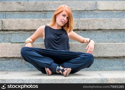 Fashionable beautiful woman on the steps of a summer day