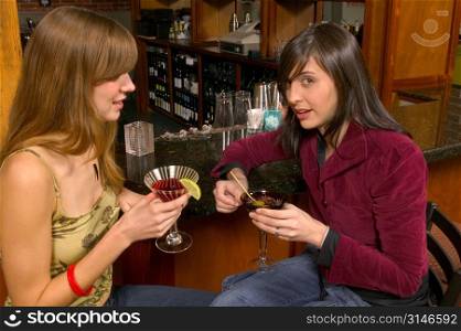 Fashionable Caucasian Girlfriends Drinking Cocktails At The Bar