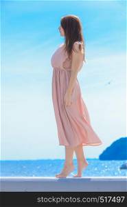 Fashionable clothing, fashion and trends concept. Woman in long dress standing and posing barefoot.. Woman in long romantic dress elegant dress