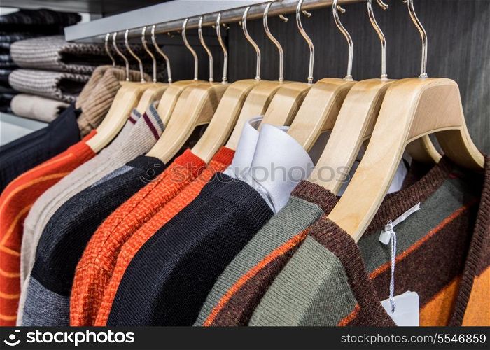 Fashionable clothing on hangers in shop