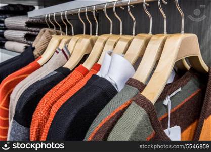 Fashionable clothing on hangers in shop