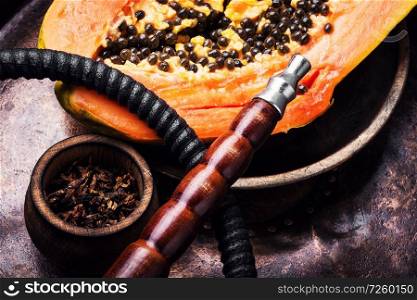 Fashionable fruit smoking hookah with a tobacco flavor of papaya.Eastern shisha.Smoking hookah.. Oriental shisha with papaya
