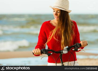 Fashionable girl with bike outdoor.. Young active girl with bicycle on seaside. Smiling cute woman resting near to sea in summer. Fashionable tourist on fresh air.