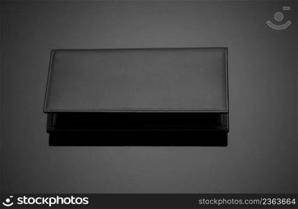 Fashionable leather men’s wallet on a dark background. men’s wallet on a black background