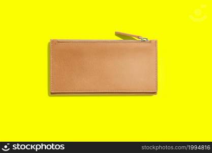 Fashionable leather women&rsquo;s wallet on a yellow background. added copy space for text.