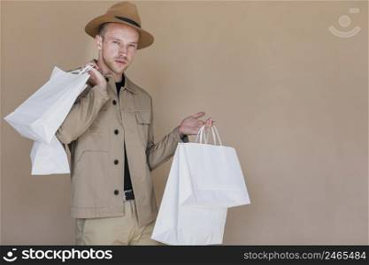 fashionable man with shopping bags looking camera