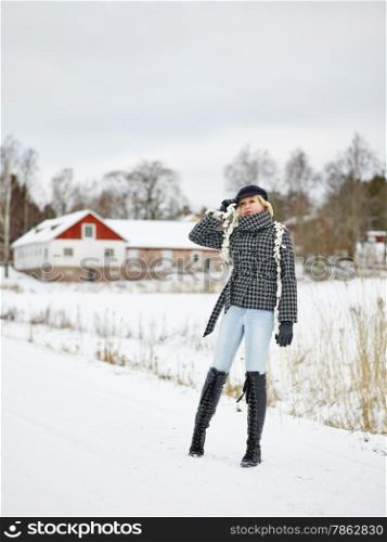 Fashionable mature adult woman wearing winter clothes, rural scene