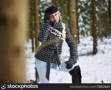 Fashionable mature adult woman wearing winter clothes, rural scene, forest on background