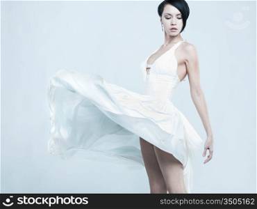 Fashionable photo of beautiful young lady in a billowing white dress
