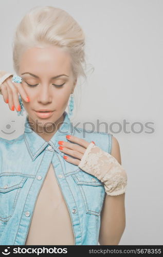 Fashionable photo of young stylish blonde in denim vest