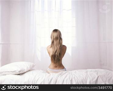 Fashionable photo sitting nude lady in a white room