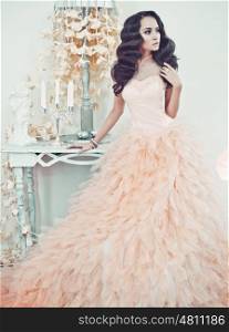 Fashionable portrait of beautiful lady in gorgeous couture dress in white interior. Holidays &amp; Events. Evening dress. Princess dress