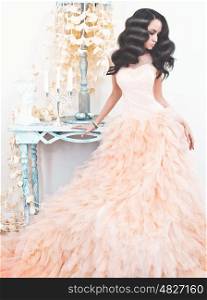Fashionable portrait of beautiful lady in gorgeous couture dress in white interior. Holidays &amp; Events. Evening dress. Princess dress