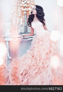 Fashionable portrait of beautiful lady in gorgeous couture dress in white interior. Holidays &amp; Events. Evening dress. Princess dress