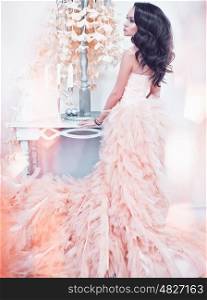Fashionable portrait of beautiful lady in gorgeous couture dress in white interior. Holidays & Events. Evening dress. Princess dress