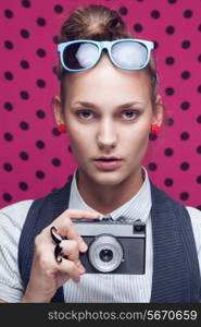 Fashionable teen with old camera in checkered red shirt and bow-tie.